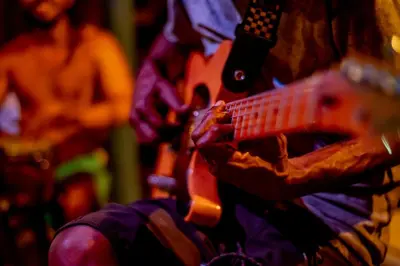 a man playing a guitar with a woman in the background at Beautiful Cabaña facing the Caribbean Sea! in Cartagena de Indias