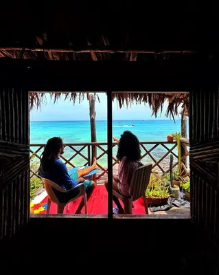 two women sitting in chairs looking at the beach at Beautiful Cabaña facing the Caribbean Sea! in Cartagena de Indias