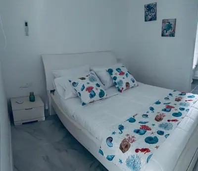 a white bed with pillows on it in a bedroom at Casa Turbay in Cartagena de Indias