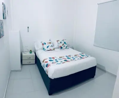 a bed in a white room with a white floor at Casa Turbay in Cartagena de Indias
