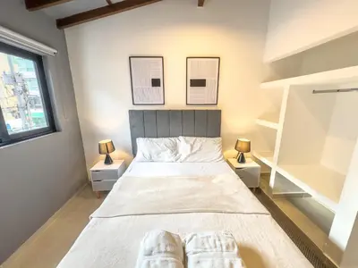 a bedroom with a large bed with two night stands at Casa Martina Manga Cartagena in Cartagena de Indias