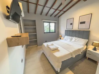 a bedroom with a bed and a flat screen tv at Casa Martina Manga Cartagena in Cartagena de Indias
