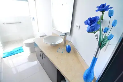 a bathroom with a blue vase with blue flowers in it at Moderno 3 Alcobas Frente a Playa in Cartagena de Indias