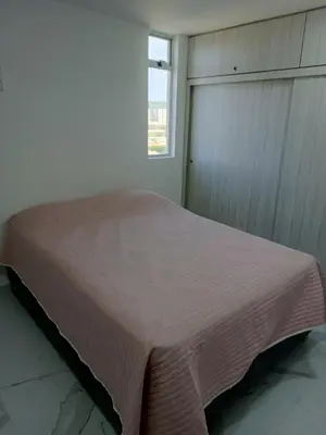 a bed in a room with a window at Búho, alameda del río in Barranquilla
