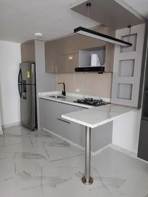 a kitchen with a counter and a refrigerator at Búho, alameda del río in Barranquilla