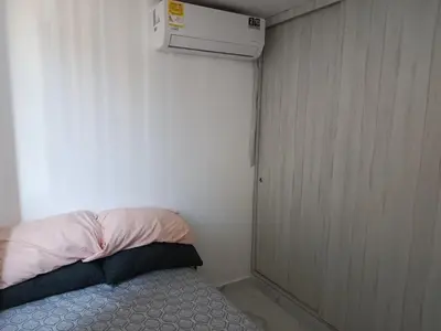 a small room with a bed and a air conditioner at Búho, alameda del río in Barranquilla