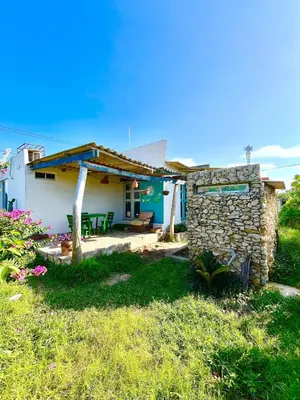 a small house with a stone wall at Hermosa Cabaña privada cerca a la Playa in Puerto Colombia