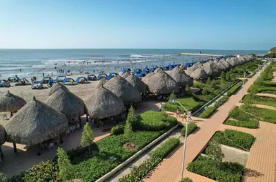 a row of umbrellas and chairs on a beach at Hermosa Cabaña privada cerca a la Playa in Puerto Colombia