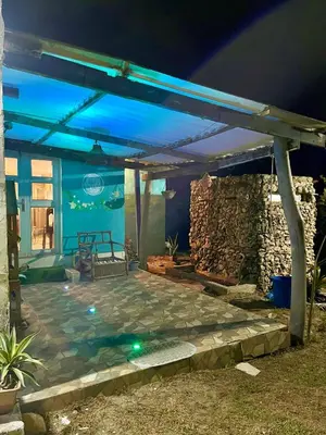 a patio lit up at night with a pergola at Hermosa Cabaña privada cerca a la Playa in Puerto Colombia