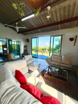 a living room with white couches and red pillows at Hermosa Cabaña privada cerca a la Playa in Puerto Colombia