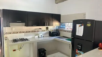a kitchen with black cabinets and a black refrigerator at La Morada Apartamento in Coveñas