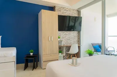 a bedroom with a blue accent wall and a bed at CB1622 | Suite frente al mar con balcón y piscina in Cartagena de Indias