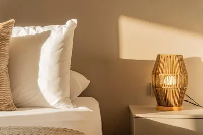 a bed with white pillows and a lamp on a night stand at Acogedora Suite Frente al Mar - Aeropuerto CB617 in Cartagena de Indias