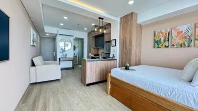 a bedroom with a bed and a chair and a kitchen at Loft familiar con balcón y piscina CB840 in Cartagena de Indias