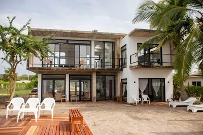 a large house with a deck and chairs at Taipan Casa de Playa in El Puertón