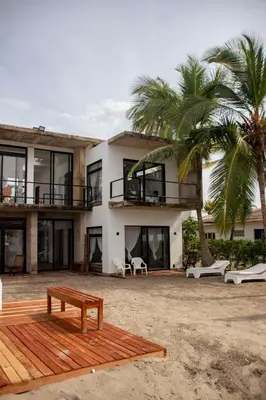 a house on the beach with a bench in front of it at Taipan Casa de Playa in El Puertón