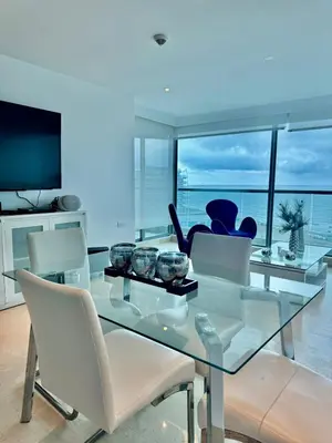 a dining room with a glass table and white chairs at Beautiful 2 BR Ocean View Condo in Cartagena in Cartagena de Indias