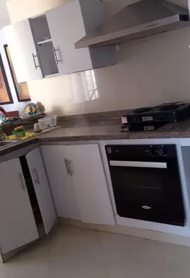 a kitchen with white cabinets and a black oven at Bahia del caribe Apartment in Cartagena de Indias