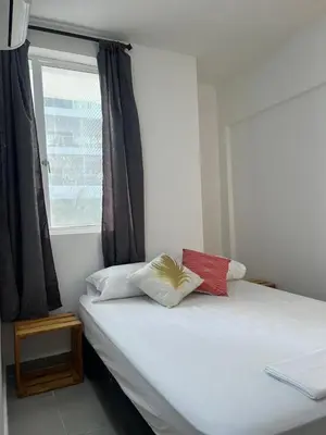 a bed with two pillows on it with a window at Habitación cerca de la playa 201 in Cartagena de Indias