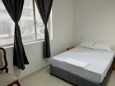 a bed sitting in a room with a window at Habitación cerca de la playa 202 in Cartagena de Indias