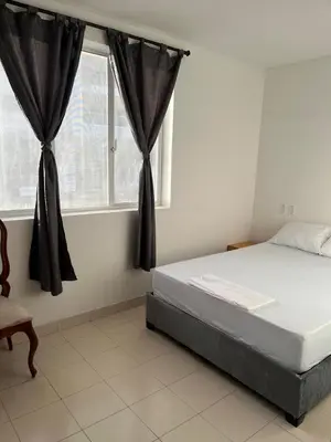 a bedroom with a bed and a window with curtains at Habitación cerca de la playa 202 in Cartagena de Indias