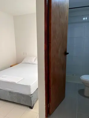 a bedroom with a bed and a door to a bathroom at Habitación cerca de la playa 202 in Cartagena de Indias