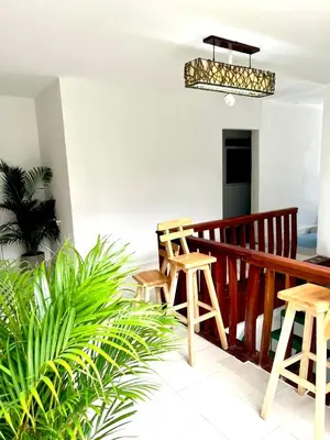 a balcony with wooden stools and a potted plant at Habitación cerca de la playa 202 in Cartagena de Indias