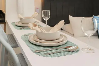 a white table with two plates and glasses on it at Suite Cama King Balcon Vista Hermosa CB634 in Cartagena de Indias