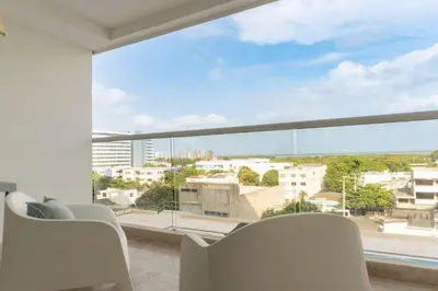 a living room with white chairs and a large window at Suite Cama King Balcon Vista Hermosa CB634 in Cartagena de Indias