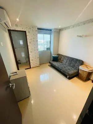 a living room with a bed in the corner of a room at aptobibibarranquilla in Barranquilla