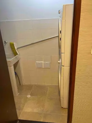 a small bathroom with a sink and a refrigerator at aptobibibarranquilla in Barranquilla