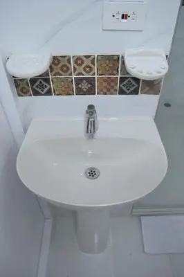 a bathroom with a white sink and two mirrors at Bocagrande cerca del mar in Cartagena de Indias