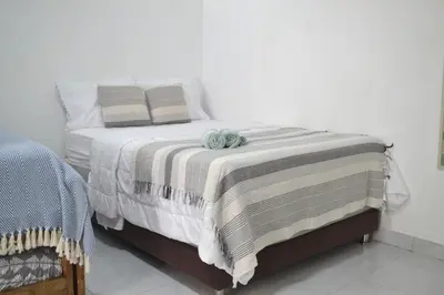 a bed with a blanket and two pillows on it at Bocagrande cerca del mar in Cartagena de Indias