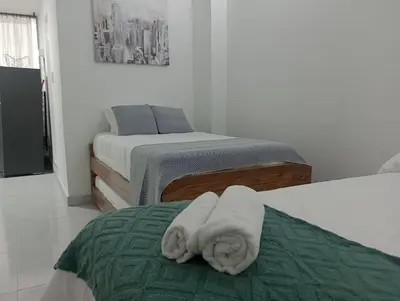a room with two beds with towels on the bed at Bocagrande cerca del mar in Cartagena de Indias