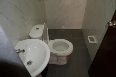 a bathroom with a white toilet and a sink at Hostal Barrio Abajo in Barranquilla