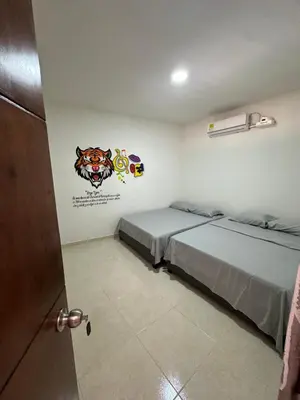 a bedroom with two beds and a sticker on the wall at Hostal Barrio Abajo in Barranquilla