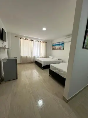 a hotel room with two beds and a television at Hotel Restaurante Arrecife in Isla de Tierra Bomba