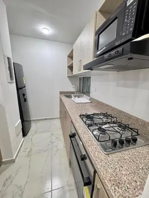 a kitchen with a stove and a microwave at Apartamento en el Norte de Barranquilla in Barranquilla
