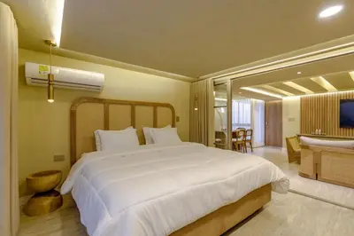 a bedroom with a large white bed and a bathroom at Suites la iglesia in Cartagena de Indias