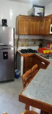 a kitchen with a stainless steel refrigerator and wooden cabinets at Apartamento en Bello Horizonte, Santa Marta in Santa Marta