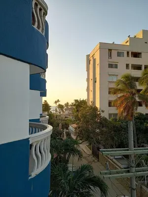 a balcony of a building with palm trees and buildings at Apartamento en Bello Horizonte, Santa Marta in Santa Marta