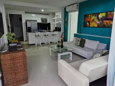 a living room with white furniture and a blue wall at Apartamento con vista al Mar Cartagena Morros 3 in Cartagena de Indias