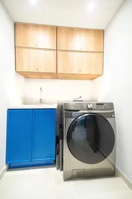 a washing machine in a kitchen with blue cabinets at Apartment Hilton Garden Inn Building in Barranquilla