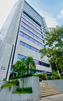 a tall building with a tree in front of it at Apartment Hilton Garden Inn Building in Barranquilla