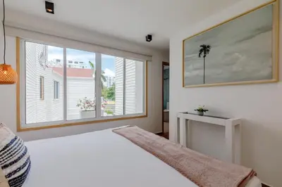 a bedroom with a white bed and a large window at Lux Beach House, Aldaba Selection in Cartagena de Indias