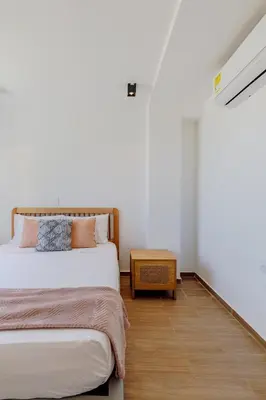 a bedroom with two beds and a wooden floor at Lux Beach House, Aldaba Selection in Cartagena de Indias
