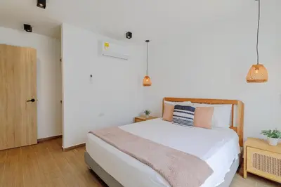 a bedroom with a large white bed with pillows at Lux Beach House, Aldaba Selection in Cartagena de Indias