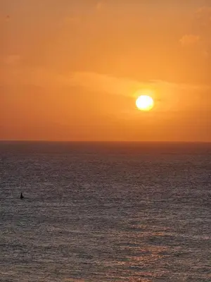 a person surfing in the ocean at sunset at Vacation Home with water views in every room! in Cartagena de Indias