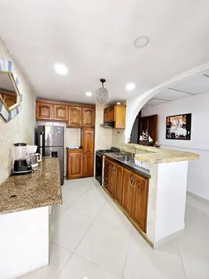 a kitchen with wooden cabinets and a counter top at Vacation Home with water views in every room! in Cartagena de Indias