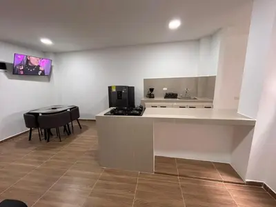 a kitchen with a counter and a table and a stove at Apartamento Villa Mary C-202 in Coveñas